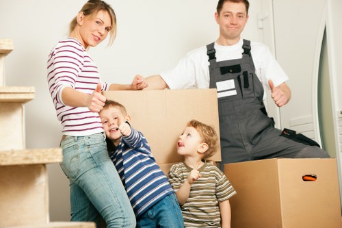 Movers carrying household furniture through a narrow hallway in a Tolworth home